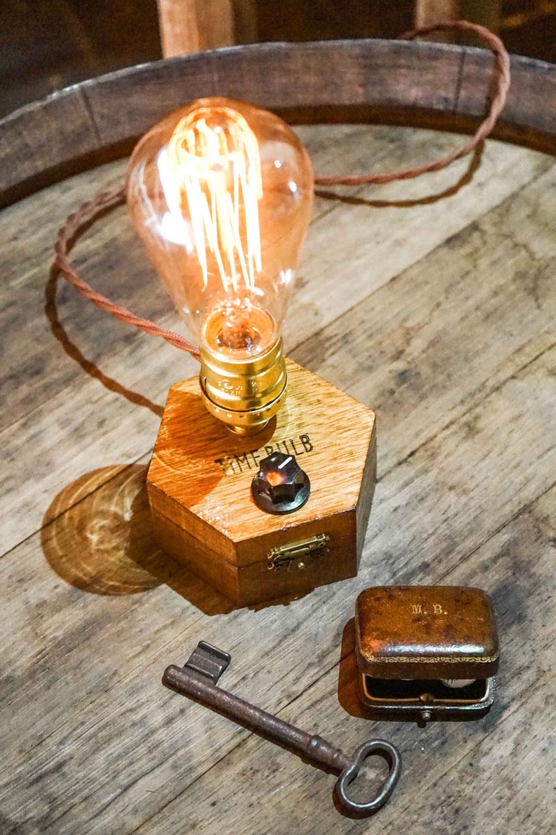 Dimmbare Tischlampe TIMEBULB Dim | Bakelit Knopf Dimmschalter Tischleuchte | Goldene Fassung Edison Birne | Minimalistisches Rustikales Industriedesign Holz Hexagon | Deko Geschenk. Available on Artigiano In Fiera 2024, Milano.