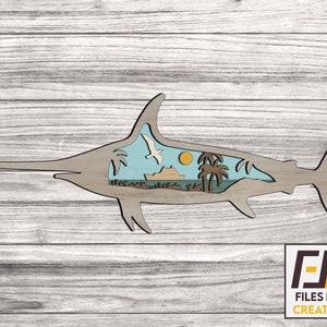 May include: A wooden cutout of a sailfish with a tropical island scene inside. The sailfish is light brown and the scene includes palm trees, a boat, and a blue sky with a yellow sun.