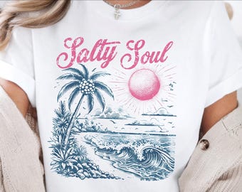May include: White t-shirt with a beach-themed graphic. The design features a palm tree, ocean waves, and a pink sun, with the words "Salty Soul" in pink script. The shirt is a digital download.
