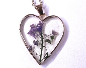 Halsband med lila blommor och guldfärgat hjärta