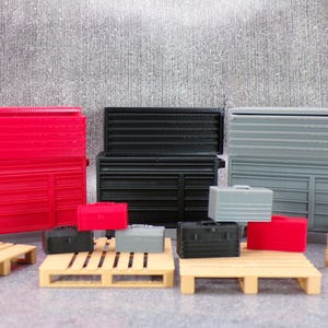 May include: A set of three miniature toolboxes in red, black and grey, with smaller toolboxes and wooden pallets. The toolboxes have multiple drawers and are made of plastic.