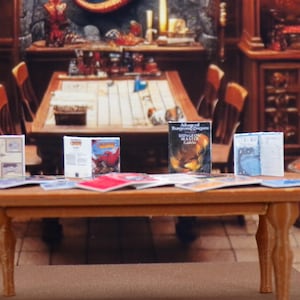 May include: A miniature wooden table with six miniature Dungeons & Dragons game books on top. The books are titled "Advanced Dungeons & Dragons Dungeon Master Guide" and "Advanced Dungeons & Dragons" with various illustrations.