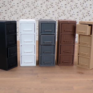 May include: Five miniature file cabinets in different colors: black, white, gray, brown, and beige. Each cabinet has four drawers.