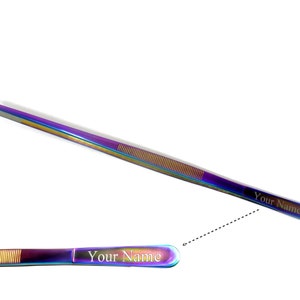 Könnte beinhalten: Eine Pinzette in Regenbogenfarben mit einer goldenen Gravur, die "Your Name" lautet.