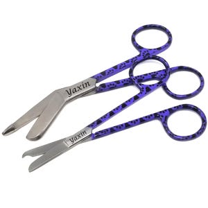 May include: Two surgical scissors with purple handles and black paw print patterns. The scissors have silver blades and the word "Yaxin" is printed on the blades.