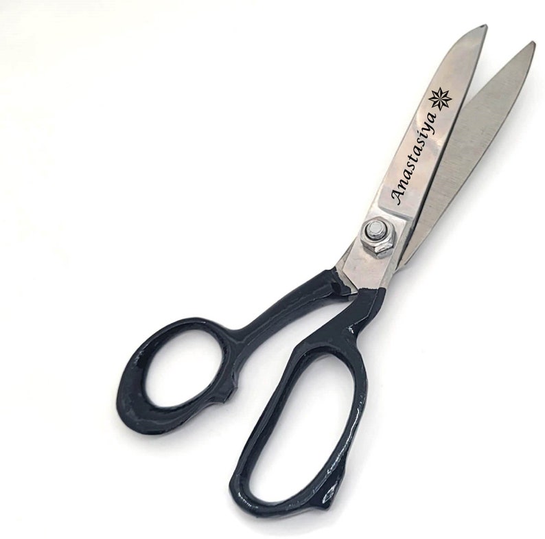 May include: Shears with black handles and a silver blade. The blade is engraved with the text "Anastasiya" and a star.