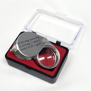 May include: A silver magnifying glass with a black case. The magnifying glass has the inscription "If loving jewelry is wrong, I don't want to be right."