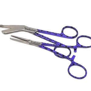 May include: A pair of purple and black paw print patterned surgical forceps with the word "Webster" engraved on each handle.