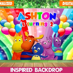 May include: A birthday backdrop with the name "Ashton" in bright colours, with the text "is turning 2." The design includes cartoon characters, balloons, and a rainbow background. The words "Personalized" and "Digital File" are at the top.