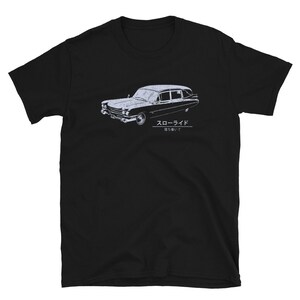 Puede incluir: Camiseta negra con un gráfico blanco de una carroza fúnebre vintage y el texto "Slow Ride" en japonés. El texto debajo del coche dice "Tómalo con calma".