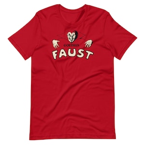 Peut inclure: T-shirt rouge avec une illustration noire et blanche d'un diable avec le texte "Goethe's Faust" en blanc.