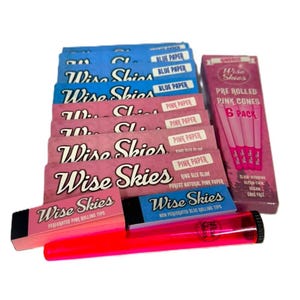 May include: A collection of Wise Skies rolling papers and accessories. The image shows packs of blue and pink rolling papers, pre-rolled pink cones, perforated pink rolling tips, and a neon pink rolling tube.