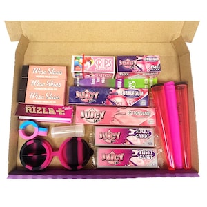May include: An open box filled with various smoking accessories, including rolling papers, filters, tips, and a pink and black silicone pipe. The box also contains a variety of colorful candy-themed rolling papers, including "Juicy Jay's", "Sticky Candy", and "Cotton Candy".
