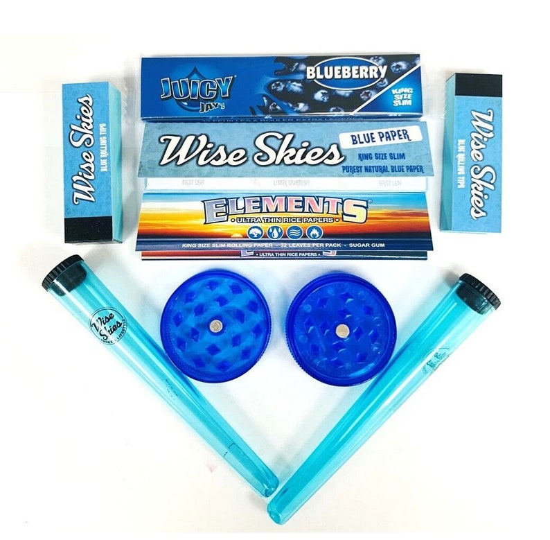 May include: A blue and white smoking kit with two grinders, two rolling tubes, and three packs of rolling papers. The rolling papers are labelled "Wise Skies", "Juicy Jays", and "Elements".