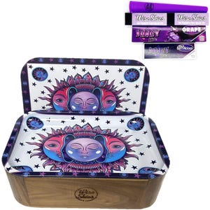 May include: A wooden rolling tray with a two-tier design. The top tier features a white background with a purple, pink, and blue sun and moon design. The bottom tier is a wooden box with the Wise Skies logo. The tray is accompanied by a set of rolling papers with various designs, including Wise Skies, Juicy Jay's, and Black Berrylicious.