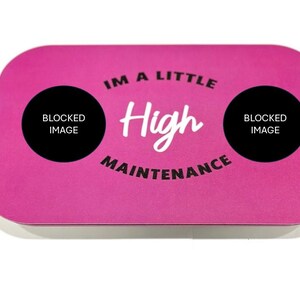 May include: Pink rectangular coaster with the text "I'm a little High Maintenance" in white lettering. The text is surrounded by two black circles with the text "Blocked Image" in white lettering.
