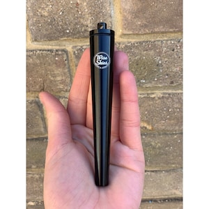 Puede incluir: Un tubo de metal negro con un logotipo plateado que dice "Wise Skies". El tubo mide aproximadamente 12,5 cm de largo y tiene una parte superior redondeada.