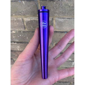 May include: A purple metal tube with a screw-on lid and the words "Wise Skies" engraved on the side.