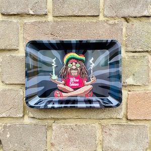 May include: A black and white zebra patterned metal rolling tray featuring a cartoon image of a person with dreadlocks wearing a red shirt with the text "Wise Skies" and a green and white glass pipe.