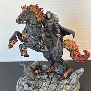 May include: A black horse with flaming mane and tail, ridden by a figure in a black cloak and red accents. The horse and rider are standing on a stone base with skulls.