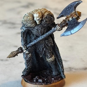 May include: A miniature figurine of a skeletal warrior in dark armor, holding a double-bladed axe. The figure has a fur-lined cloak and stands on a circular base. The color palette includes shades of black, gray, and bronze.