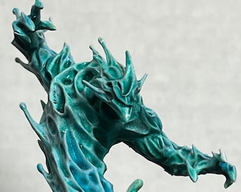 Pode incluir: Escultura turquesa de uma criatura fantástica com um design orgânico texturizado. A figura tem uma coroa pontiaguda e um braço estendido, com uma aparência fluida semelhante à água. A escultura é detalhada e parece ser feita de cerâmica ou material similar.