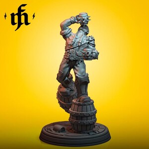 Könnte beinhalten: Graue Figur eines Mannes, der auf zwei Fässern steht und einen stacheligen Krug über dem Kopf hält. Die Figur trägt ein detailliertes Outfit mit Riemen und Rüstung. Der Sockel ist rund mit einem strukturierten Design. Der Hintergrund ist einfarbig gelb.