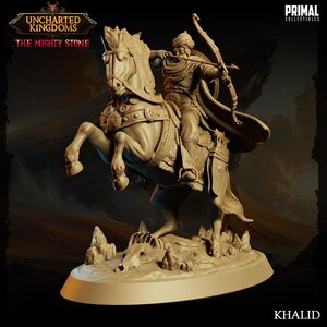 May include: A detailed sculpture of a warrior on horseback, drawing a bow. The figure is dressed in ornate attire, with a flowing cape. The base features the text "KHALID" and the logos for "UNCHARTED KINGDOMS" and "PRIMAL COLLECTIBLES".