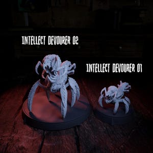 May include: Two gray, insect-like sculptures labeled "INTELLECT DEVOURER 02" and "INTELLECT DEVOURER 01." The larger sculpture is on a round base. The smaller sculpture is on a similar base. The sculptures have multiple legs and a menacing appearance.