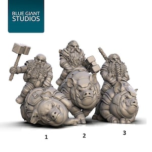 May include: Three miniature dwarf figurines riding war pigs. Each dwarf has a long beard and is holding a weapon. The figurines are numbered 1, 2, and 3. The Blue Giant Studios logo is in the upper left corner.