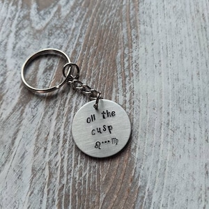 May include: Silver keychain with a round tag that says "On the cusp  Aquarius - Pisces".