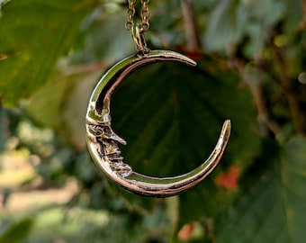 Small crescent moon pendant with brass face