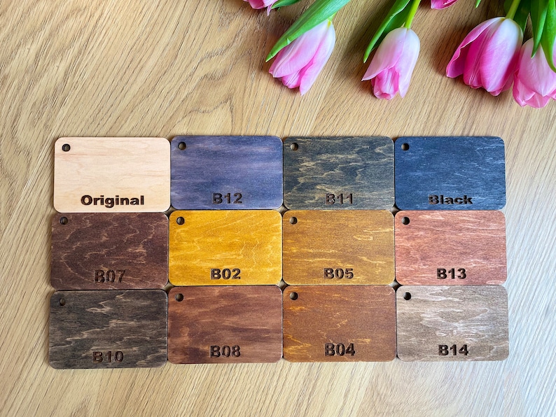 K&ouml;nnte beinhalten: Eine Holzbeizfarbkarte mit 12 verschiedenen Holzbeizfarben, darunter Original, B12, B11, Schwarz, B07, B02, B05, B13, B10, B08, B04 und B14.
