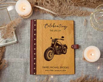 Pode incluir: Um livro de homenagem em madeira com uma gravura de motocicleta e o texto "Celebrating the Life of Daniel Michael Brooks". O livro tem lombada e fecho em couro, com velas e elementos decorativos.