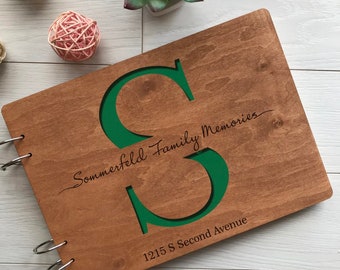 May include: A wooden photo album with a green letter "S" cut out of the front cover. The album is personalized with the text "Sommerfeld Family Memories" and "1215 S Second Avenue".