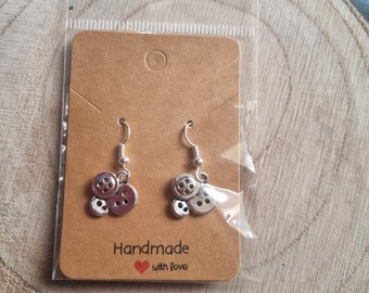 May include: Silver button earrings with a brown card that says "Handmade with love".