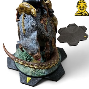 Puede incluir: Figura de fantasía detallada de una criatura parecida a una rata con criaturas más pequeñas en su espalda, colocada sobre una base hexagonal. La figura está pintada en tonos de gris, marrón y verde. También hay una base hexagonal separada a juego.