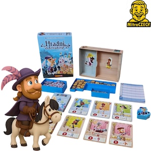 Op de afbeelding: Een bordspelset met een cartoon ridder op een paardenbeeldje, speelkaarten en een doos met de titel "Hradní Devater". Het spel bevat diverse spelstukken, een houten doos en een notitieblok. Het kleurenschema is voornamelijk blauw, bruin en beige.