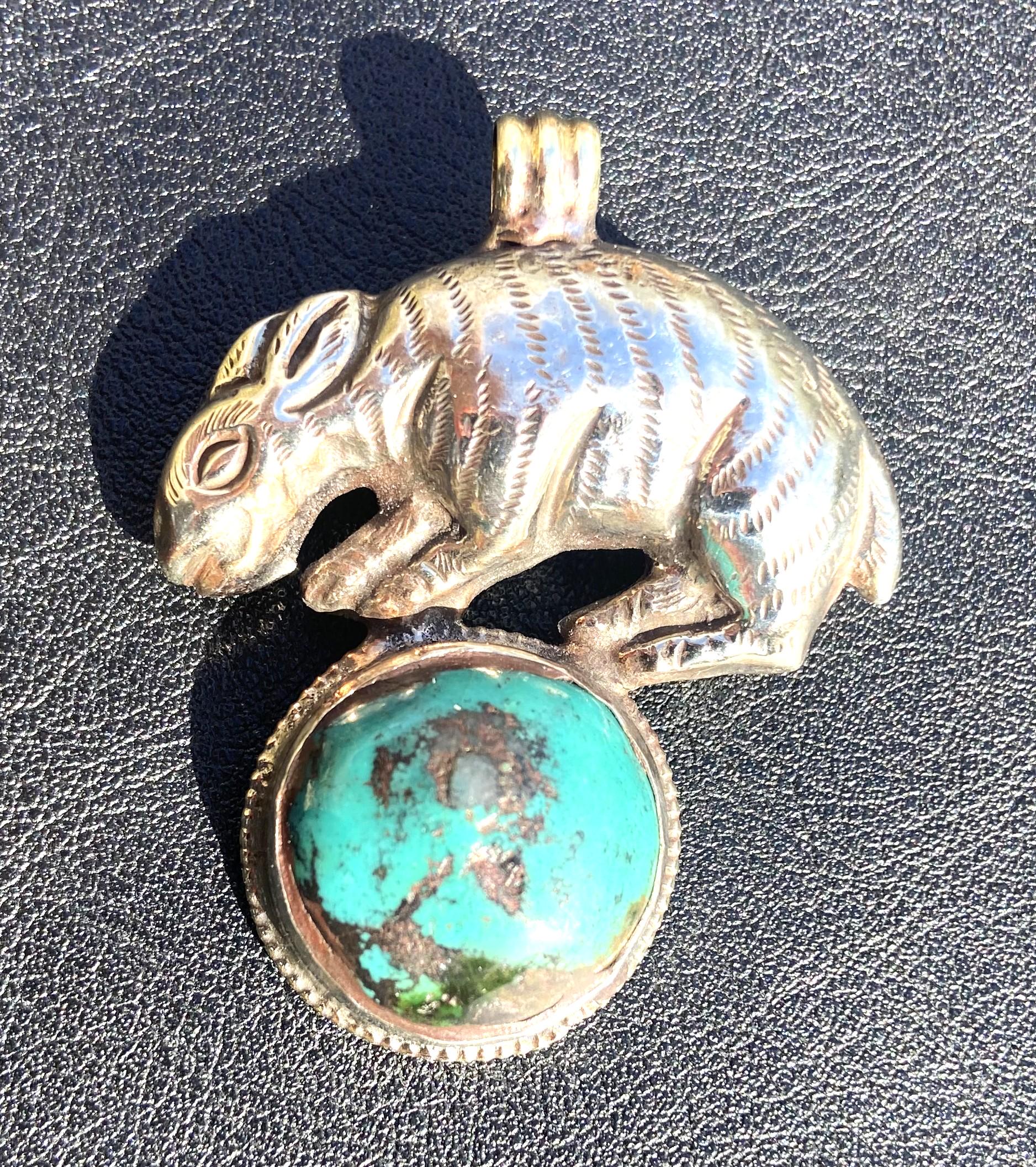 Tibetan silver pendant with rabbit on top of turquoise stone.    b