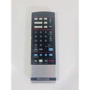 May include: A black remote control with silver accents and a silver PHILCO logo. The remote has buttons for TV, VCR, CBL, PIP, SLEEP, P.PREF, PIP FREEZE, ADV, MENU, ACH, PIP SWAP, STATUS, EXIT, ON/OFF, 1-9, 0, and more.