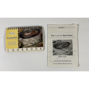 May include: A white oval Crock-Pot slow cooker with a green and white floral design. The cooker is open and filled with food. The image is accompanied by a cookbook with 50 recipes for the Crock-Pot slow cooker.