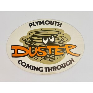 May include: Oval sticker featuring the text "PLYMOUTH DUSTER COMING THROUGH" in black and orange. The word "Duster" is in large orange letters. A cartoon tornado graphic is behind the word "Duster".