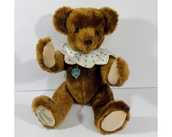 Puede incluir: Un oso de peluche marrón con un cuello blanco con lunares negros. El oso tiene una etiqueta que dice "Hermann Teddy Original" y "Fundado en 1912". El oso está sentado con los brazos y las piernas extendidos.