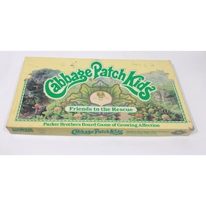 Pode incluir: Uma caixa amarela com um logotipo verde e branco Cabbage Patch Kids. A caixa apresenta o texto "Friends to the Rescue" e "Parker Brothers Board Game of Growing Affection".