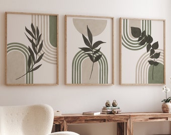 Op de afbeelding: Drie ingelijste botanische kunstprints. Elke print heeft een minimalistisch ontwerp met een neutrale achtergrond, olijfgroene bogen en donkergroene bladerillustraties. De frames zijn lichtbruin.