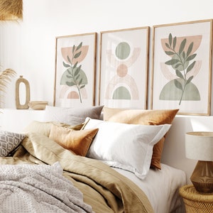 May include: Three framed abstract art prints with a minimalist design featuring green leaves, peach and green circles, and brown lines on a white background.