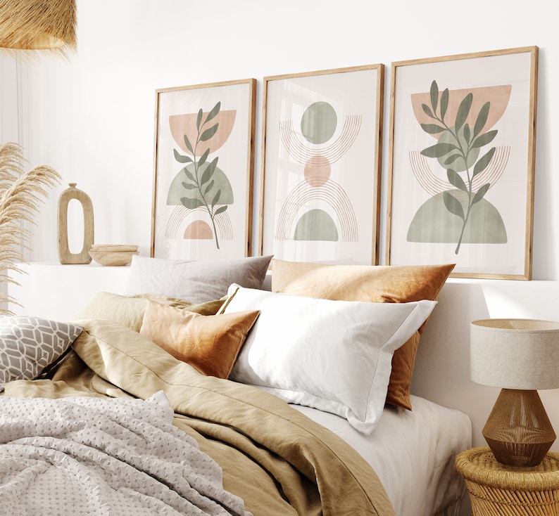 May include: Three framed abstract art prints with a minimalist design featuring green leaves, peach and green circles, and brown lines on a white background.