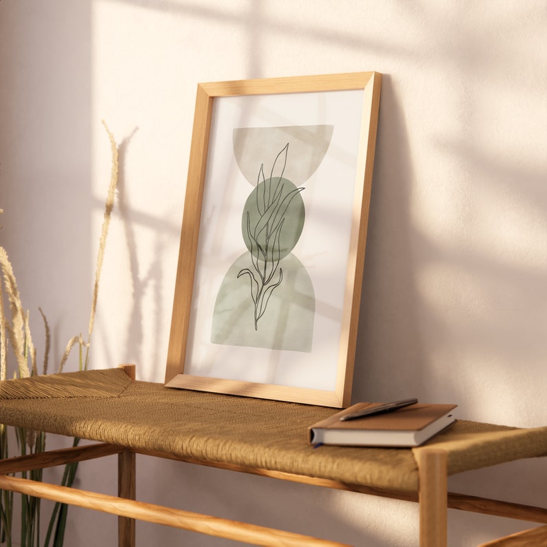 May include: A framed print with a minimalist design featuring a green leaf with a light green and white background.