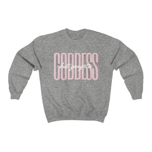 May include: A heather grey sweatshirt with the text "GODDESS but gangsta" printed in pink.