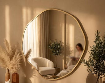 Espelho de parede redondo assimétrico, peça de destaque na decoração orgânica e moderna da casa.